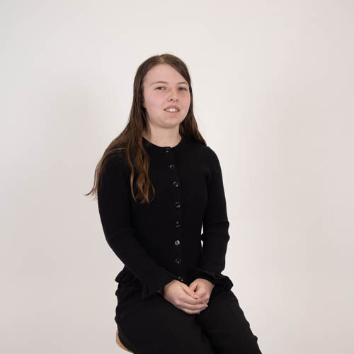 Portrait of graphic designer Hailee Kite seated against a neutral background.