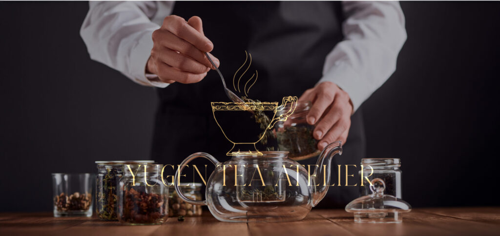Person preparing loose leaf tea with glass teapot and jars, featuring Yūgen Tea Atelier gold logo overlay